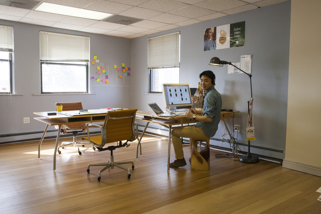 A photograph of a young man in an open office with a hardwood floor; Published as part of the post "UX Career Development"